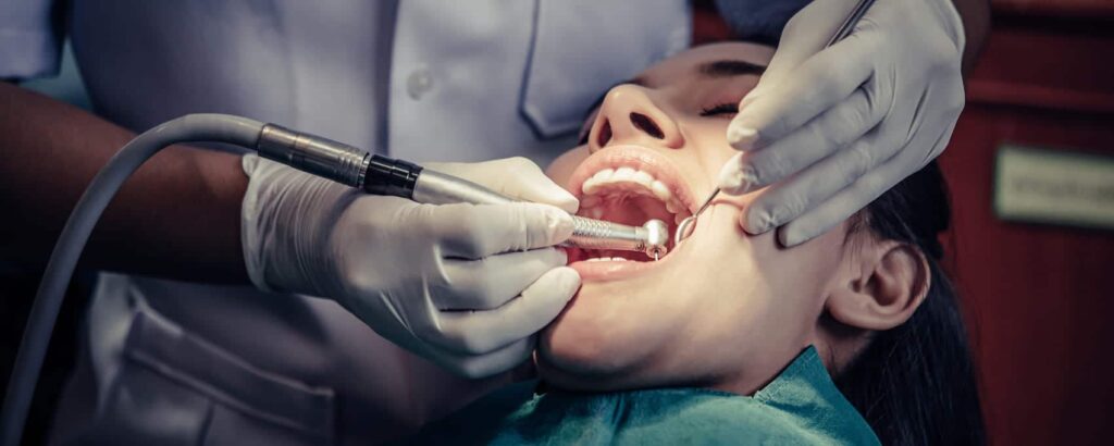 dentista realizando una periodoncia a paciente