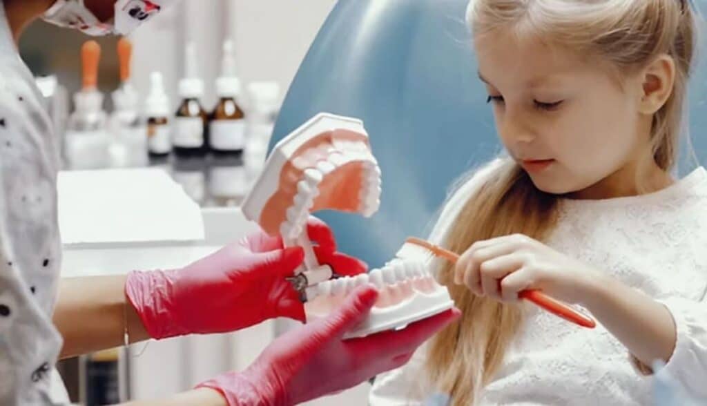 dentista ensenando paciente infantil