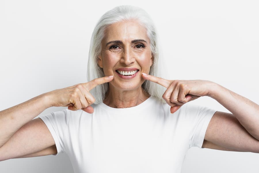 mujer adulta ensenando implantes dentales