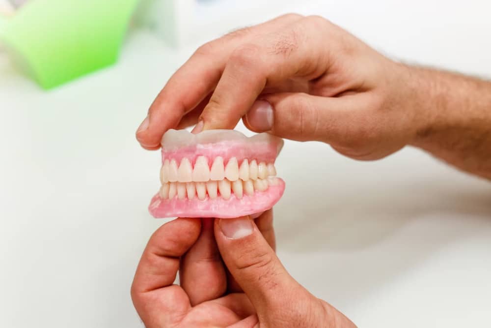 persona sujeta prótesis dentales removibles