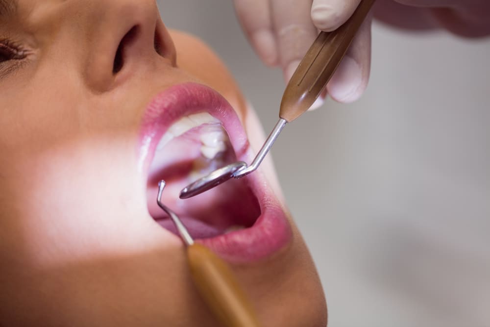 dentista examinando dientes paciente femenino