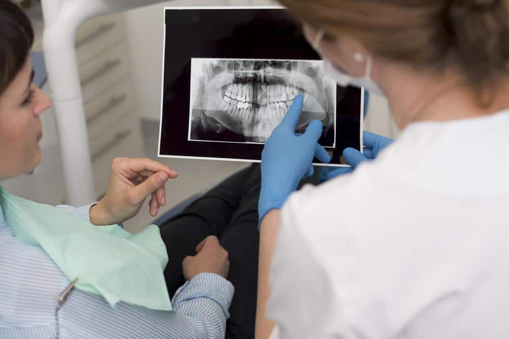 paciente sexo femenino que mira radiografia sus dientes dentista