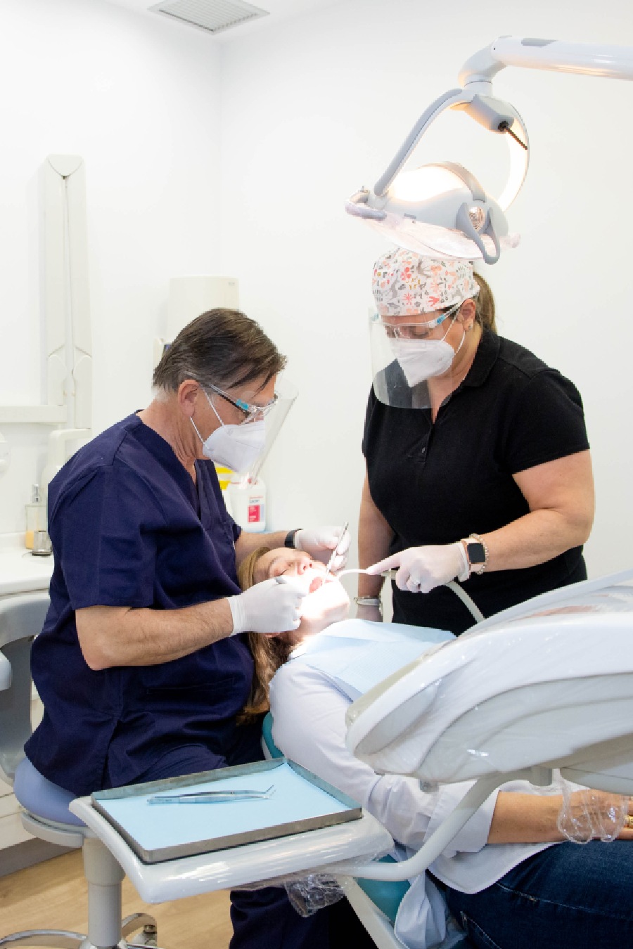 dentista trabajando en la boca de una paciente